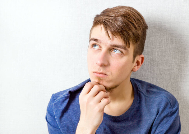 Young Man is Thinking at the Home by the Wall - Fotoğraf, Görsel
