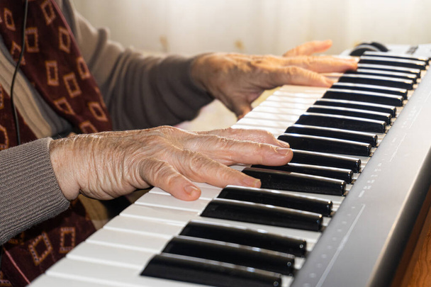 Kaukasische oudere vrouw leren muziek en het spelen van het muzikale toetsenbord - Foto, afbeelding
