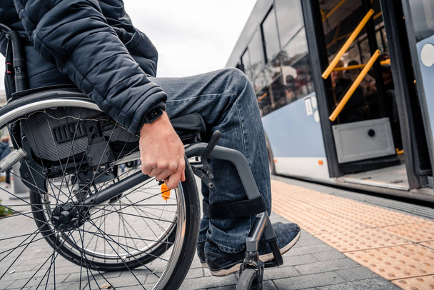 La persona con disabilità fisica entra nel trasporto pubblico con una rampa accessibile. - Foto, immagini