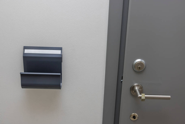 Close up view of modern iron entrance door indoors with doorknob and shelf for correspondence. Sweden. - Foto, Imagem