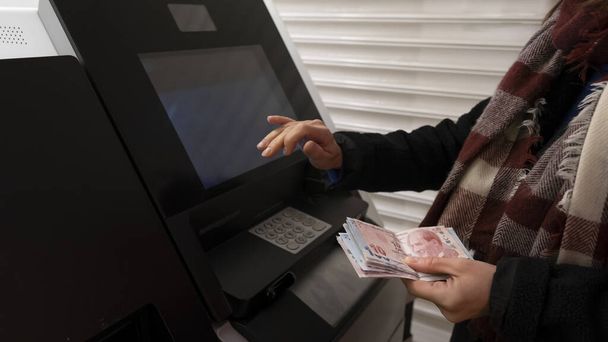 Vrouw geld opnemen uit een geldautomaat - Foto, afbeelding