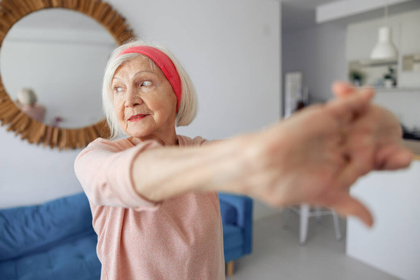 Portrait of senior woman exercising at home - Foto, Bild
