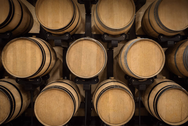 Oak barrels stacked for wine aging in winery vault - Photo, Image
