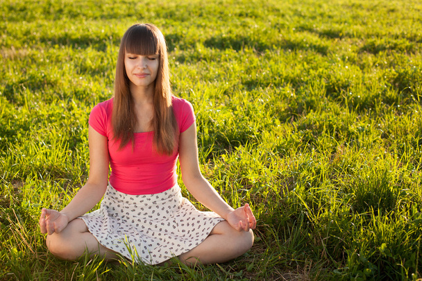 Beautiful young girl meditating - Фото, изображение