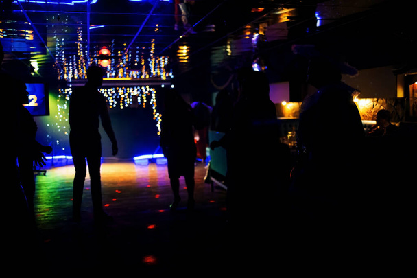 Χορεύοντας σε ένα υπόγειο κλαμπ. πίστα με τους ανθρώπους που χορεύουν κάτω από τα πολύχρωμα φώτα - Φωτογραφία, εικόνα