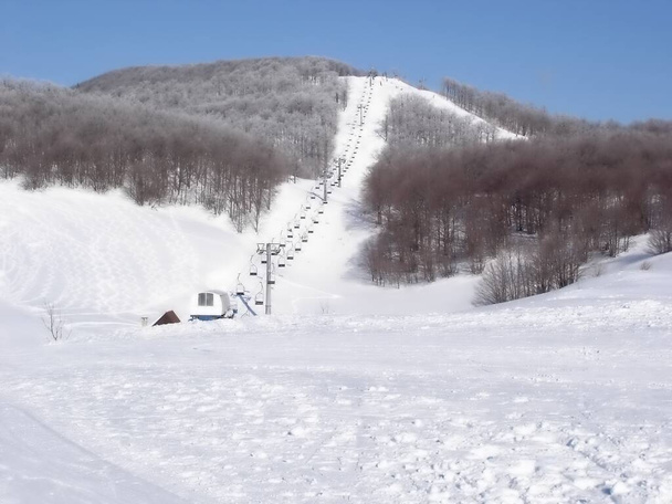 Talvivuoristomaisema. Rata hiihtoon.Tuore lumihiihtäjä kappaleita hiihtopisteessä. köysirata lumessa - Valokuva, kuva