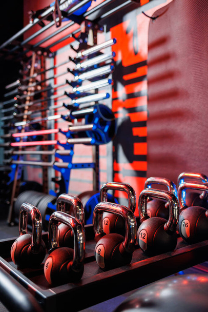 Kettlebells with various colors. Sports equipment in the gym. kettlebell for fitness training. A shot of weights lined up in a row in the gym. - Photo, Image