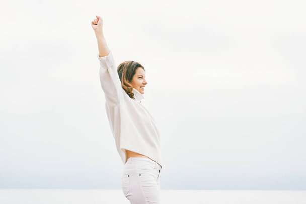 Outdoor portrait of happy strong and confident woman with her fist up in the air - Foto, Bild