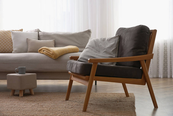 Comfortable armchair and sofa near window in living room. Interior design - Foto, Imagem