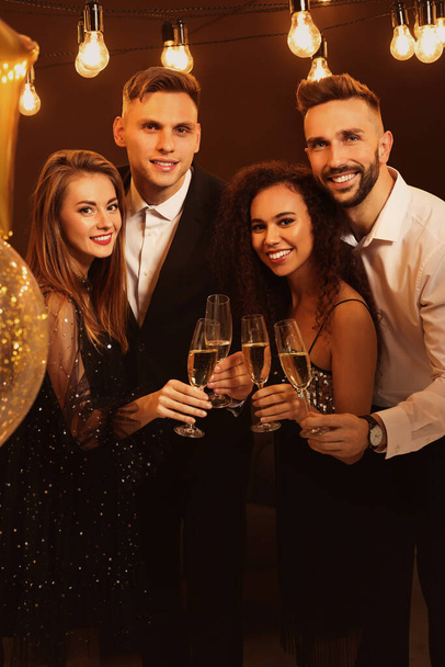 Happy friends with glasses of sparkling wine celebrating New Year indoors - Foto, Imagen