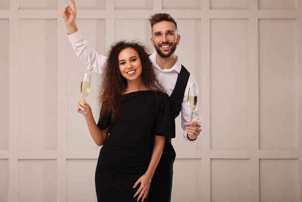 Happy couple with glasses of sparkling wine celebrating New Year indoors - Foto, imagen