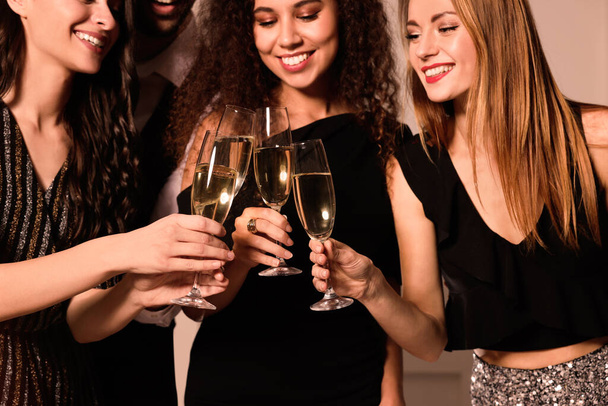 Happy friends with glasses of sparkling wine celebrating New Year indoors, closeup - Фото, зображення