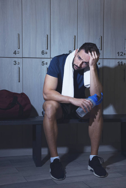 Handsome tired man with shaker in locker room - Fotografie, Obrázek