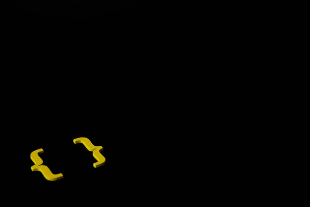 Siyah arkaplan üzerine sarı ahşap sembol "parantez" ve sosyal medya eğitim kavramı için kopyalama alanı - Fotoğraf, Görsel