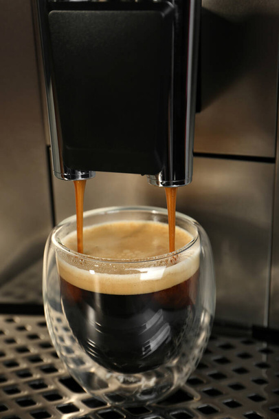Espresso machine pouring coffee into glass, closeup - Fotó, kép