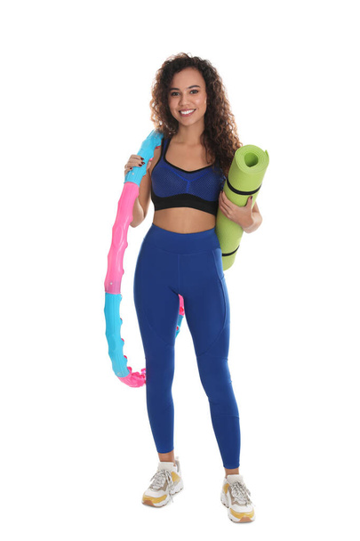 Beautiful African American woman with yoga mat and hula hoop on white background - Photo, Image