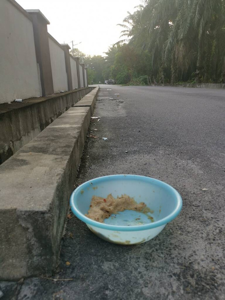 tigela de plástico azul claro sujo à beira da estrada para alimentar animais sem-teto. - Foto, Imagem