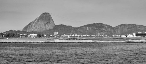 Rio de Janeiro, Brasilien - CIRCA 2021: Foto vom Zuckerhut, Pao de Acucar, mit Landebahn des Flughafens Santos Dumont und Guanabara-Bucht tagsüber - Foto, Bild