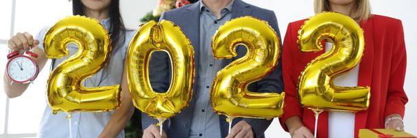 csoport üzletemberek Santa Claus kalap kezében arany léggömbök számok 2022 közel újév fa - Fotó, kép