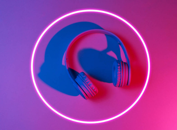 Stylish earphones. 80's synth wave and retrowave glowing circle futuristic aesthetics. Old fashioned abstraction concept - Photo, Image