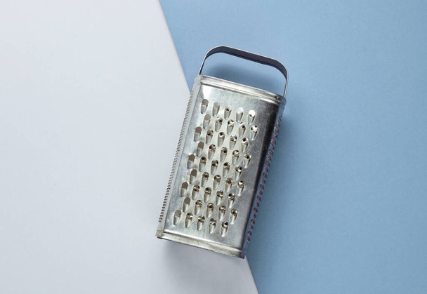 Old metal grater on a colored paper background. Top view. Studio shot - Photo, Image