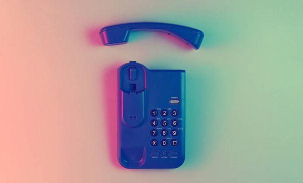 Vezeték nélküli irodai telefon telefonnal. Neon fény. Felülnézet. - Fotó, kép