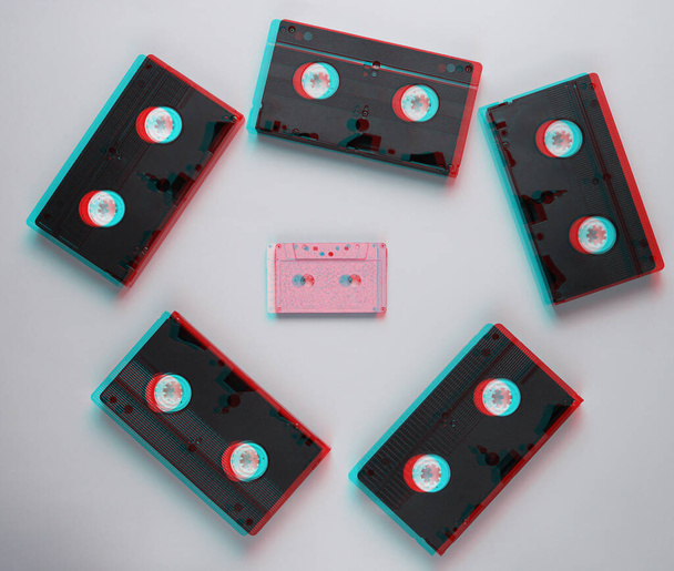 Minimalismus im Retro-Stil. Videokassette, Audiokassette auf grauem Hintergrund. Ansicht von oben. Glitch-Effekt - Foto, Bild