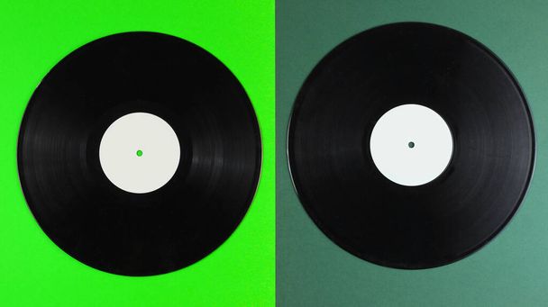 Két bakelit lemez, zöld háttérrel. Retro stílusban. Felülnézet. - Fotó, kép