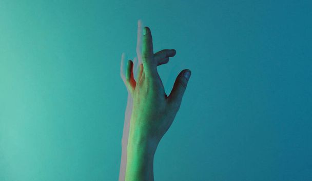 Female hand with blue holographic color light. Minimalism fashion. Surrealism. Concept art. Glitch effect - Photo, Image