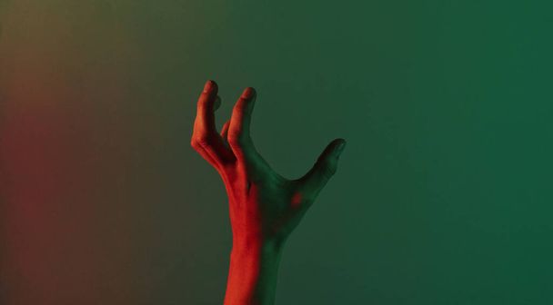 Impresionante mano femenina con luz verde roja de neón azul. Tema Halloween. Moda minimalista. Surrealismo. Arte conceptual - Foto, Imagen