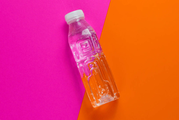 Egy palack víz színes háttérrel. Felülnézet - Fotó, kép