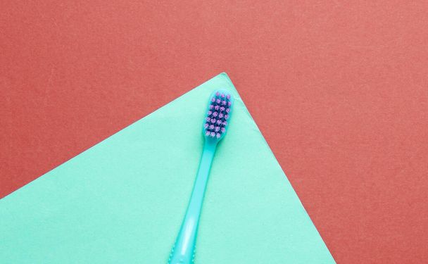 New toothbrush on colored paper background. Minimalism hygiene concept - Photo, Image