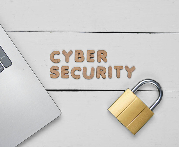 Cyber security. Laptop and Lock on white wooden background. Minimalistic concept. Top view - Fotografie, Obrázek
