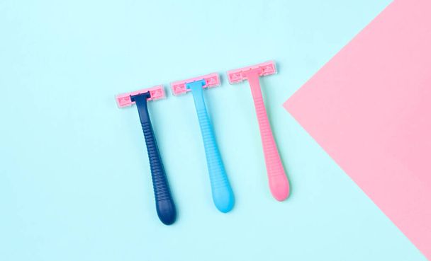 Minimalistic beauty concept. Epilation. Plastic colored razors on pastel background. Top view - Фото, изображение