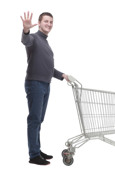 in full growth. casual young man with shopping cart. - 写真・画像