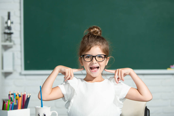 Funny school girl face with glasses. Child girl at school draws with paints. Kids artist creativity. - Foto, Imagem