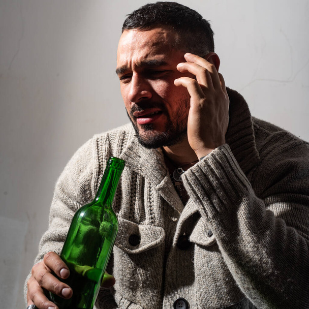 Alcoholic man with bottles wine cry. Depressed crying man. Drunk men drinking alcohol feeling lonely and desperate in emotional stress. - Фото, изображение