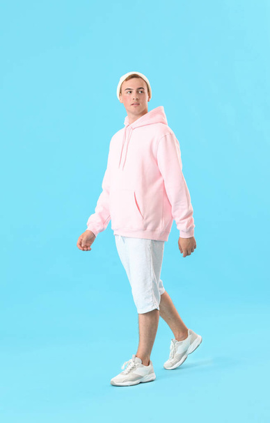 Young guy in stylish hoodie on color background - Fotó, kép