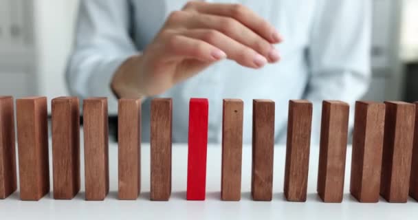Vrouwelijke hand selecteert rood blok uit rij van beige houten blokken - Video