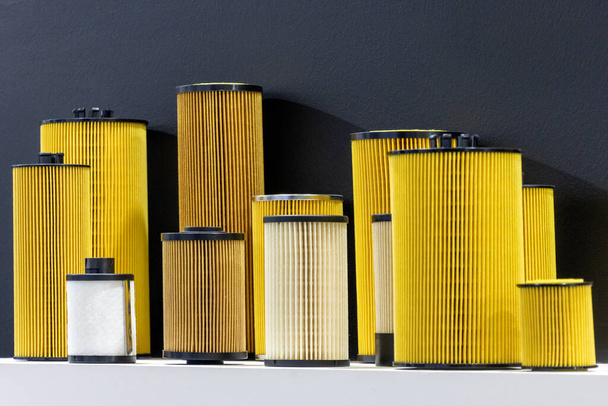 Car engine oil filters in various sizes. Isolated black background - Foto, Imagem