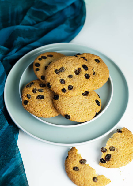 A stack of Giant cookies with raisins lies on a light green plate. Delicious homemade baked goods - Photo, Image