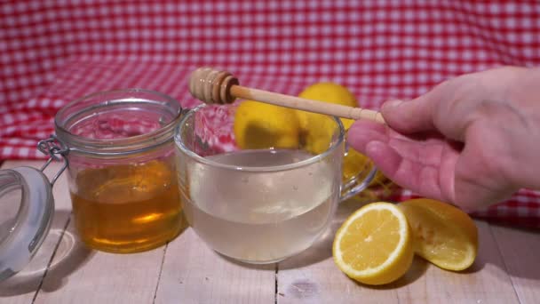 Приготовление горячего лимона и медового напитка для натурального холодного средства - Кадры, видео