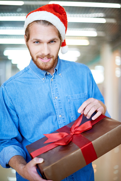 Junger Mann packt Weihnachtsgeschenk aus - Foto, Bild
