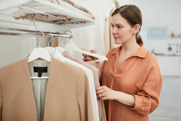 Женщина покупает одежду в магазине
 - Фото, изображение