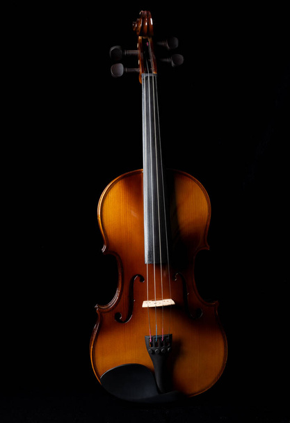 Light and shadows on a violin against a dark background. Close up. - Фото, зображення