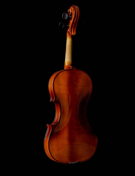 Lumière et ombre sur le dos du violon isolé sur fond noir. Espace de copie. - Photo, image