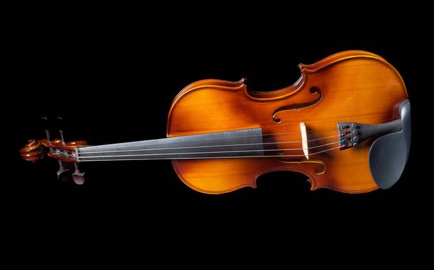 Violin lying on its side isolated on black background. Copy space. - Фото, изображение