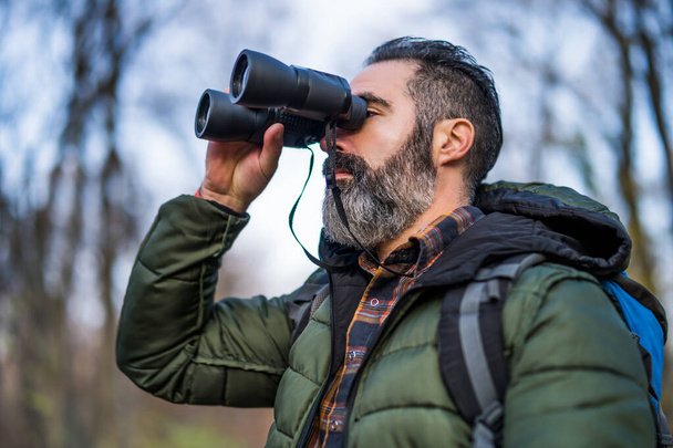 Image of man hiking and using binoculars. - Фото, зображення