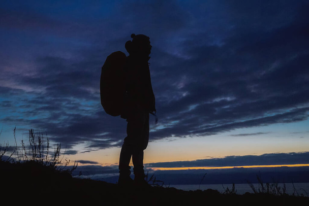 Silhouette of a hiker at sunset on Olkhon Island at Baikal - Foto, afbeelding