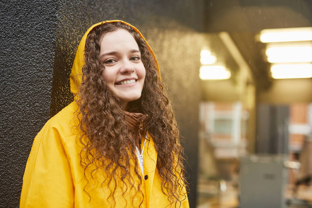 Młoda kobieta w jasnożółtym płaszczu przeciwdeszczowym - Zdjęcie, obraz